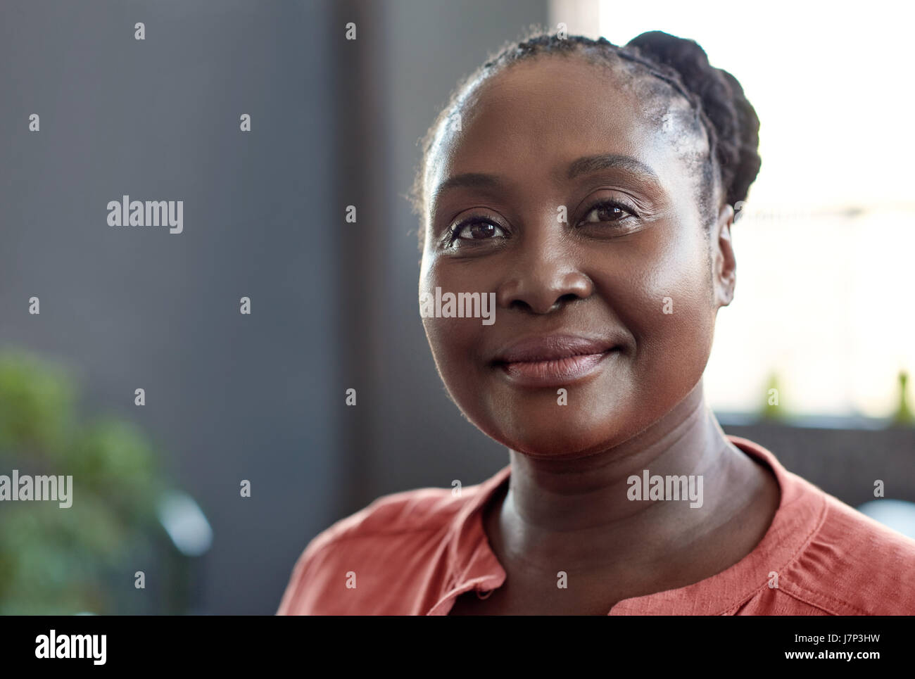 Young African businesswoman smiling confidently in a modern office Stock Photo