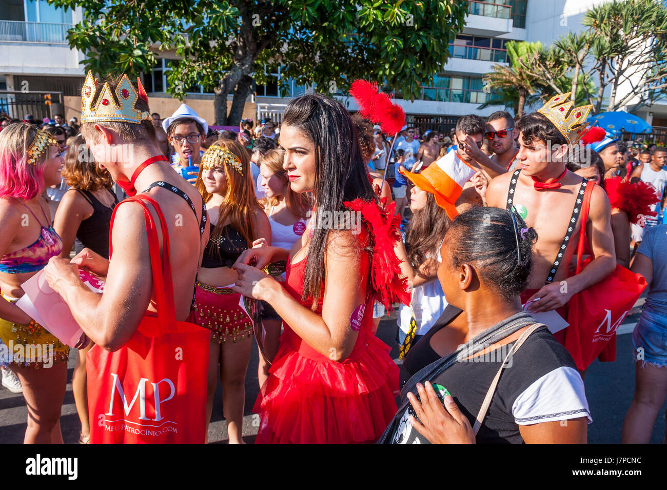 RIO DE JANEIRO - FEBRUARY 18, 2017: Young Brazilians hand out carnival promotion stickers for dating website promoting sugar daddies and sugar babies. Stock Photo