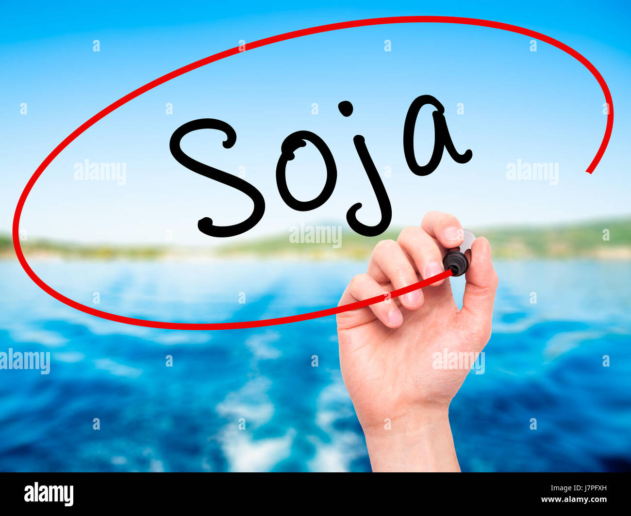 Man Hand writing Soja (Soybean in Portuguese) with black marker on