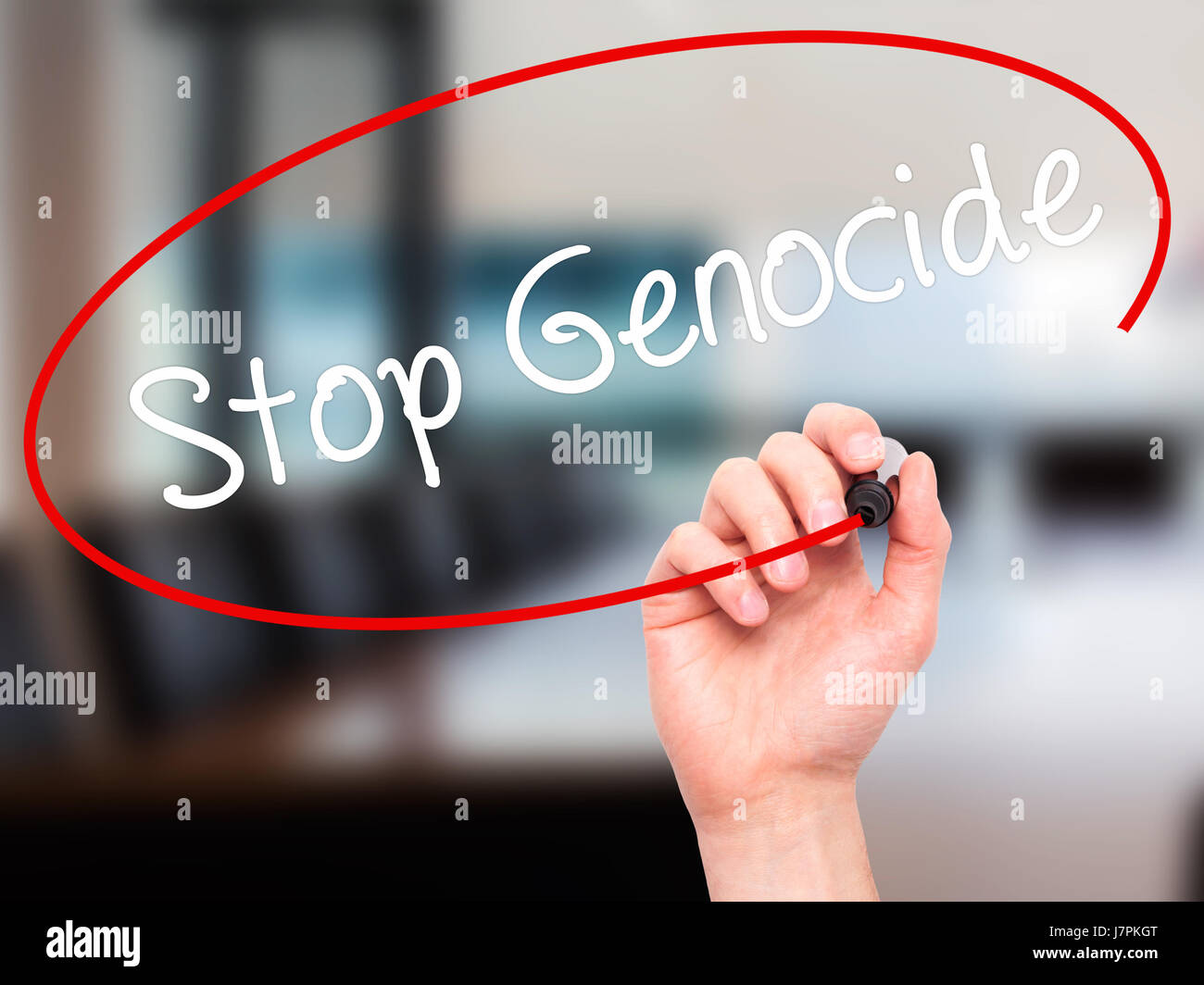 Man Hand writing Stop Genocide with black marker on visual screen. Isolated on background. Business, technology, internet concept. Stock Photo Stock Photo
