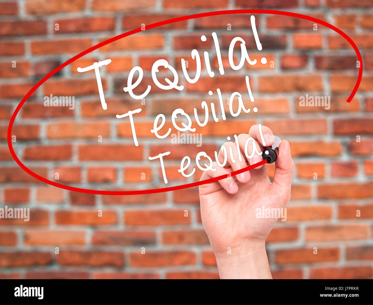 Man Hand writing Tequila with black marker on visual screen. Isolated on bricks. Business, technology, internet concept. Stock Photo Stock Photo