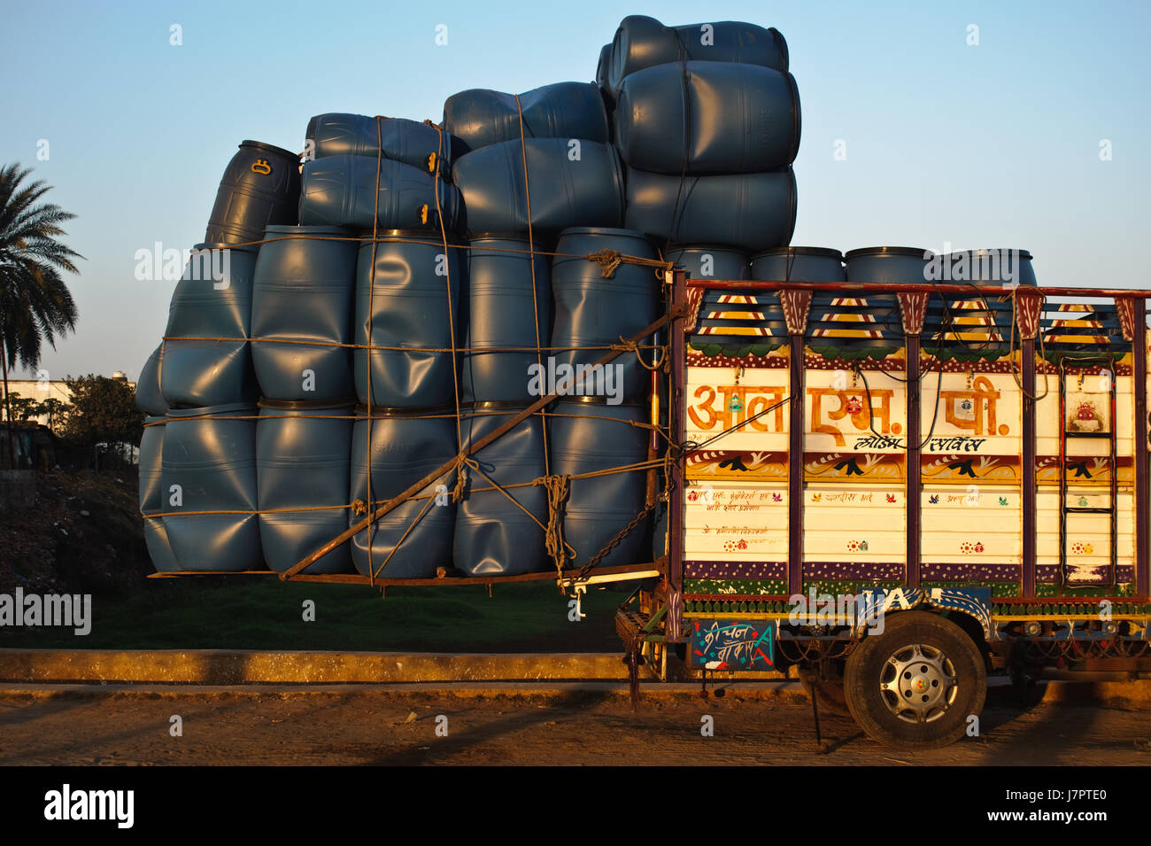Pick up truck overloaded with plastic barrels ( India). Barrels are on sale. Stock Photo