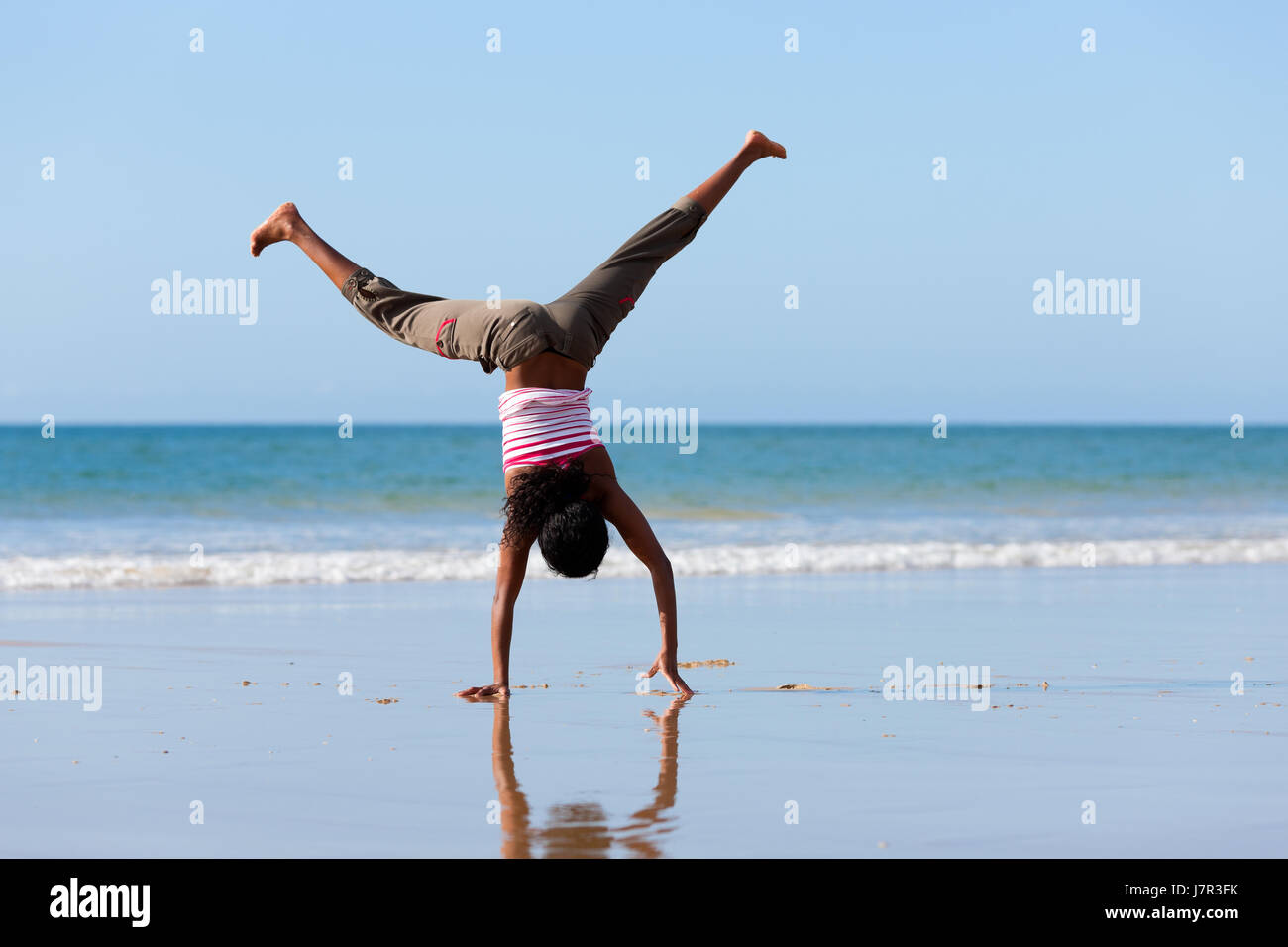 sporty woman doing gymnastics on the beach Stock Photo