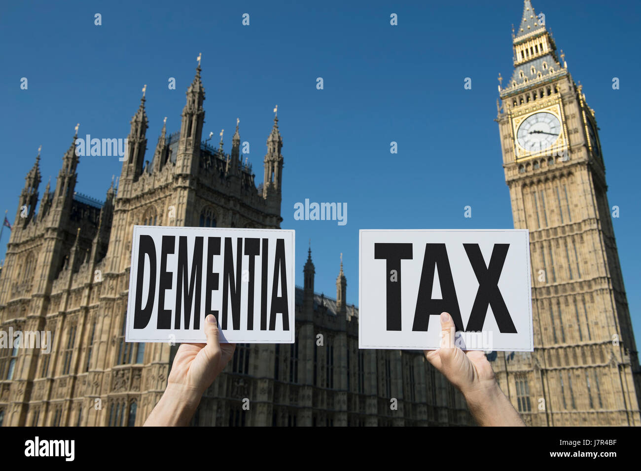 Election signs holding up the hot buttonissue of 'dementia tax' at the government Houses of Parliament at Westminster Palace in London, UK Stock Photo
