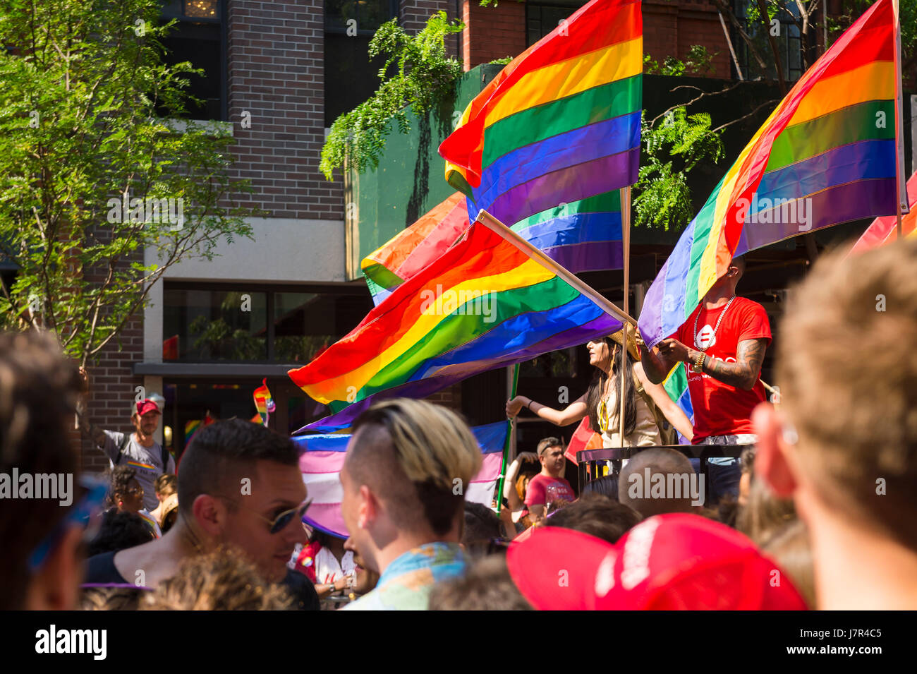 NEW YORK CITY - JUNE 26, 2015: Supporters wave rainbows flags on the sidelines of the annual Pride Parade in the famously tolerant Greenwich Village. Stock Photo