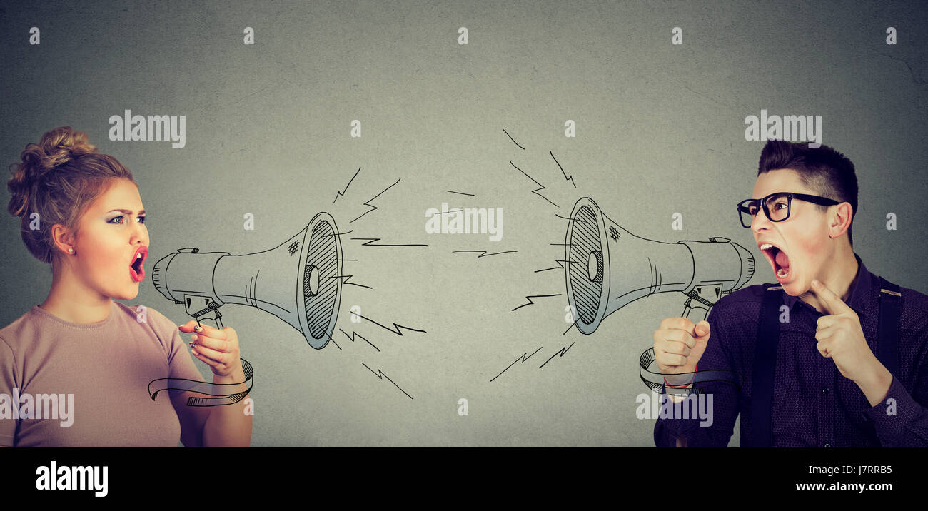 Quarrel between woman and man screaming at each other in megaphone Stock Photo