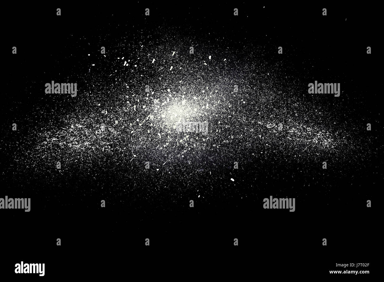 Freeze motion of white powder exploding, isolated on black, dark background. Abstract design of white dust cloud. Particles explosion screen saver, wa Stock Photo