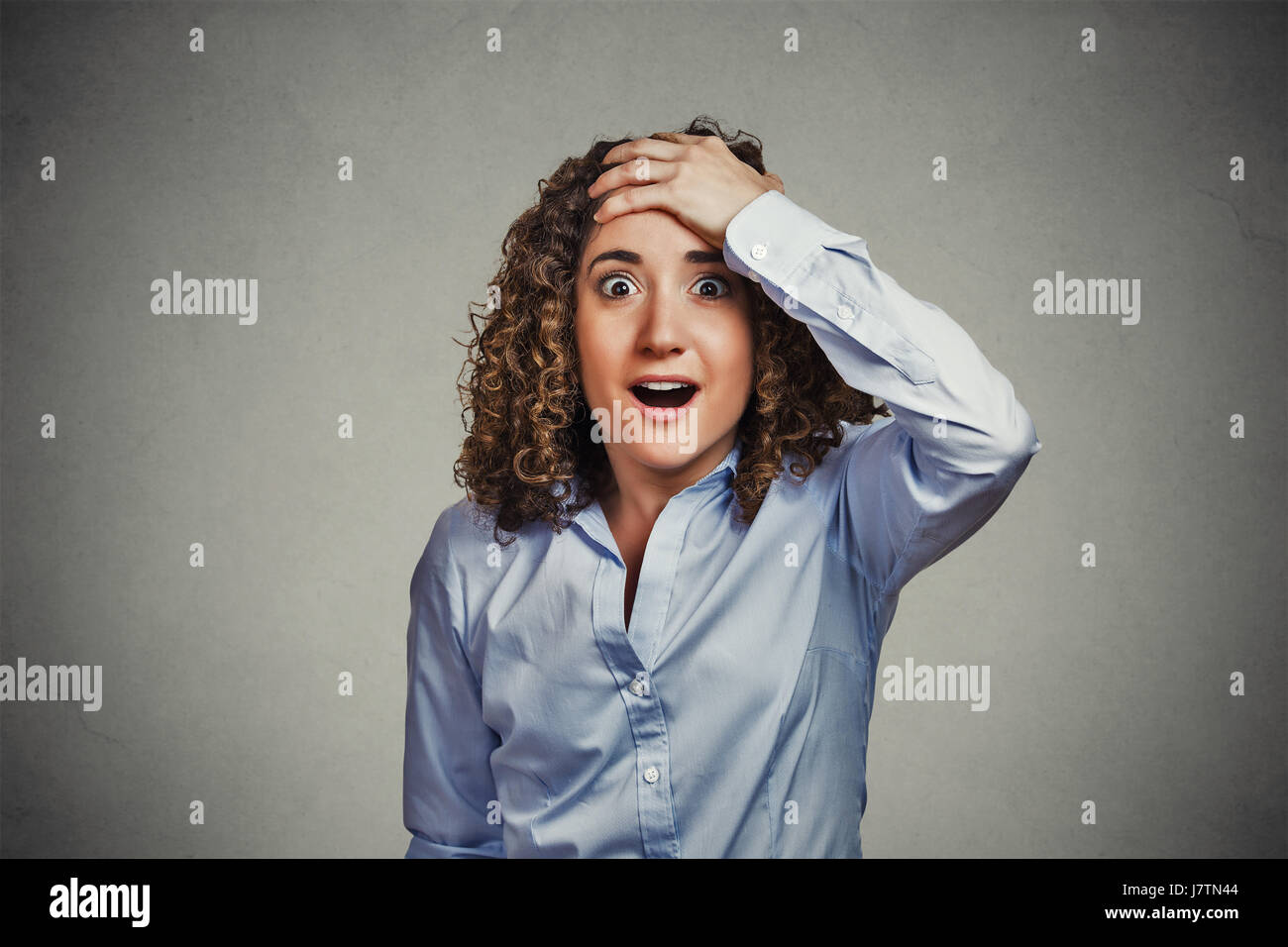 Surprise astonished woman. Closeup portrait woman looking surprised in full disbelief wide open mouth isolated gray wall background. Positive human em Stock Photo
