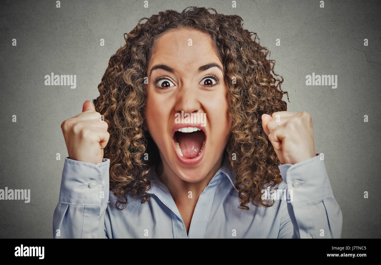 Closeup portrait headshot angry young woman having nervous breakdown screaming isolated grey wall background. Negative human emotion facial expression Stock Photo