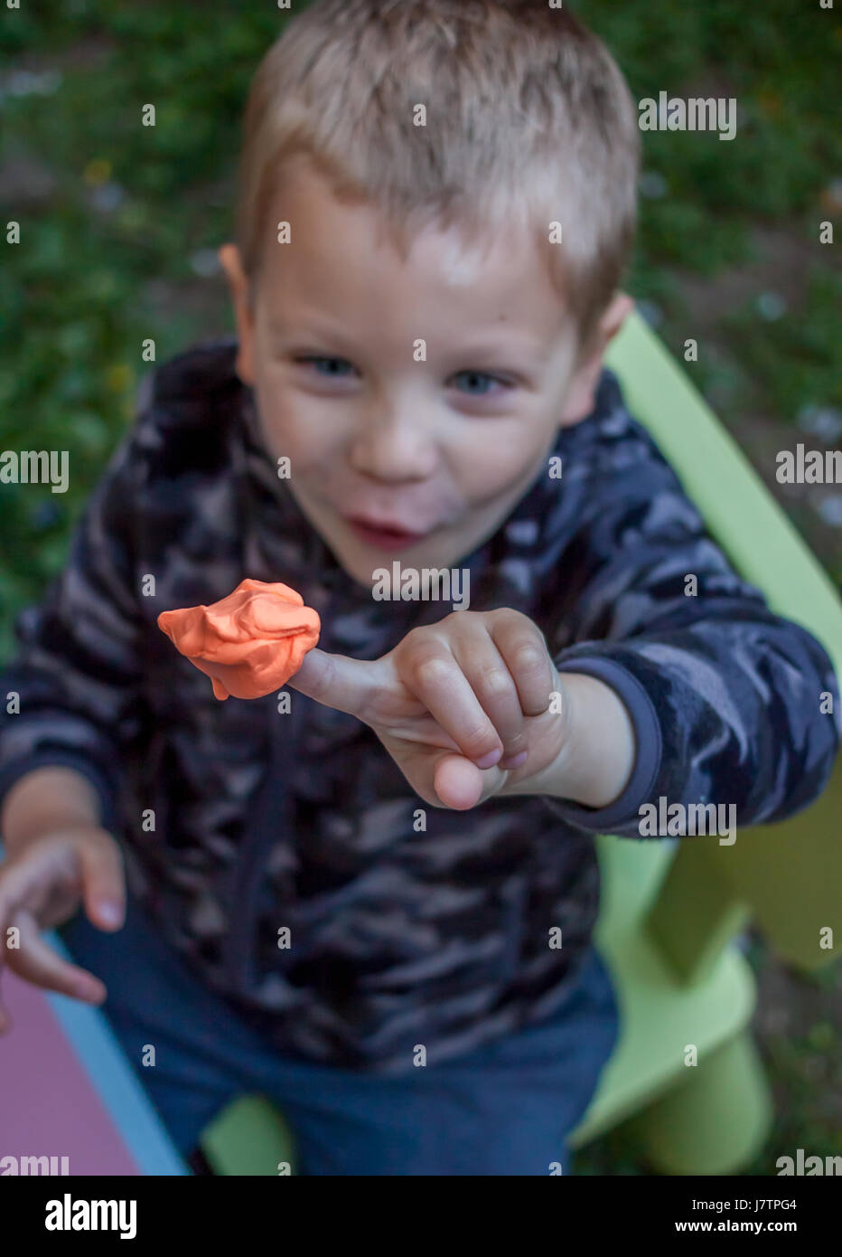 cute little boy showing bright piece of plasticine Stock Photo