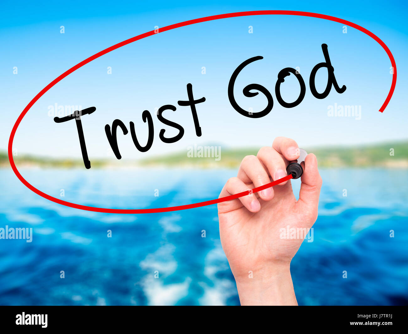 Man Hand writing Trust God  with black marker on visual screen. Isolated on nature. Business, technology, internet concept. Stock Photo Stock Photo