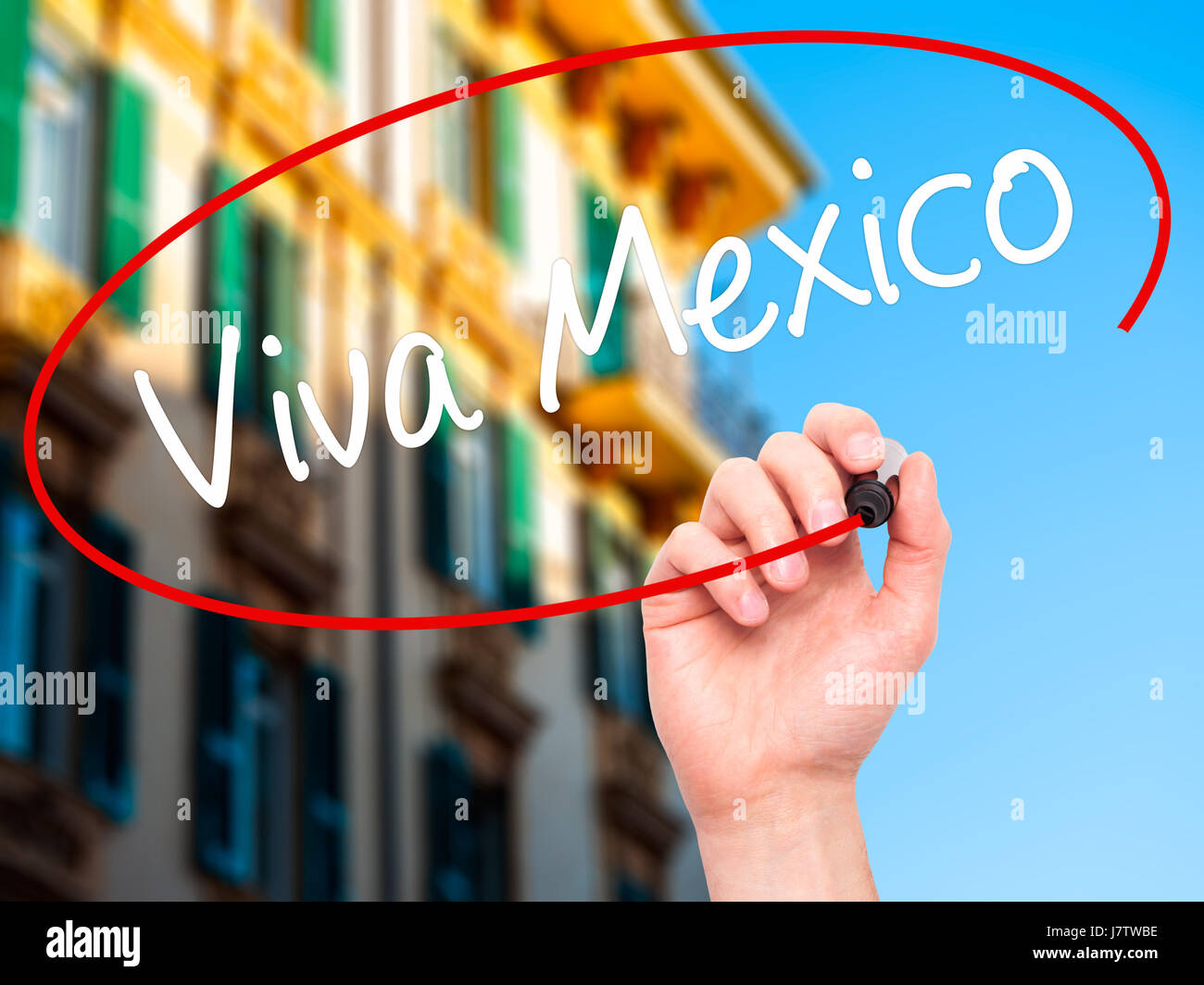 Man Hand writing Viva Mexico with black marker on visual screen. Isolated on city. Business, technology, internet concept. Stock Photo Stock Photo