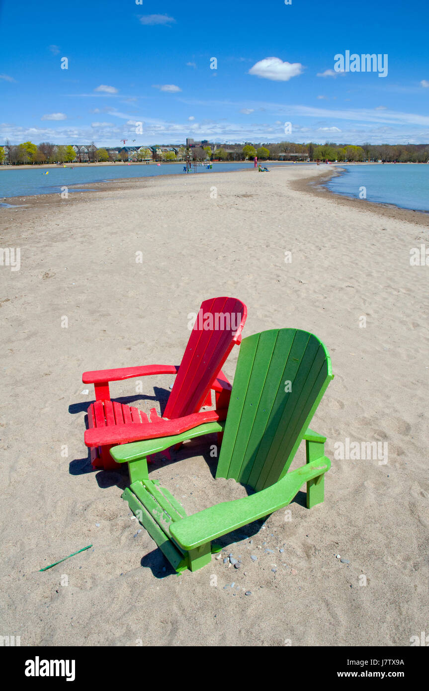 Muskoka chairs partially submerged in water and sand after springtime floods and high lake waters in Toronto, Ontario, Canada Stock Photo