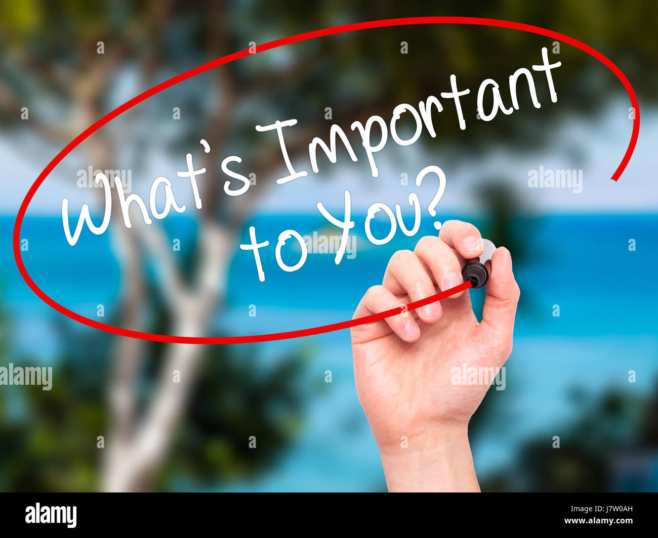 Man hand writing what s important to you with black marker on visual