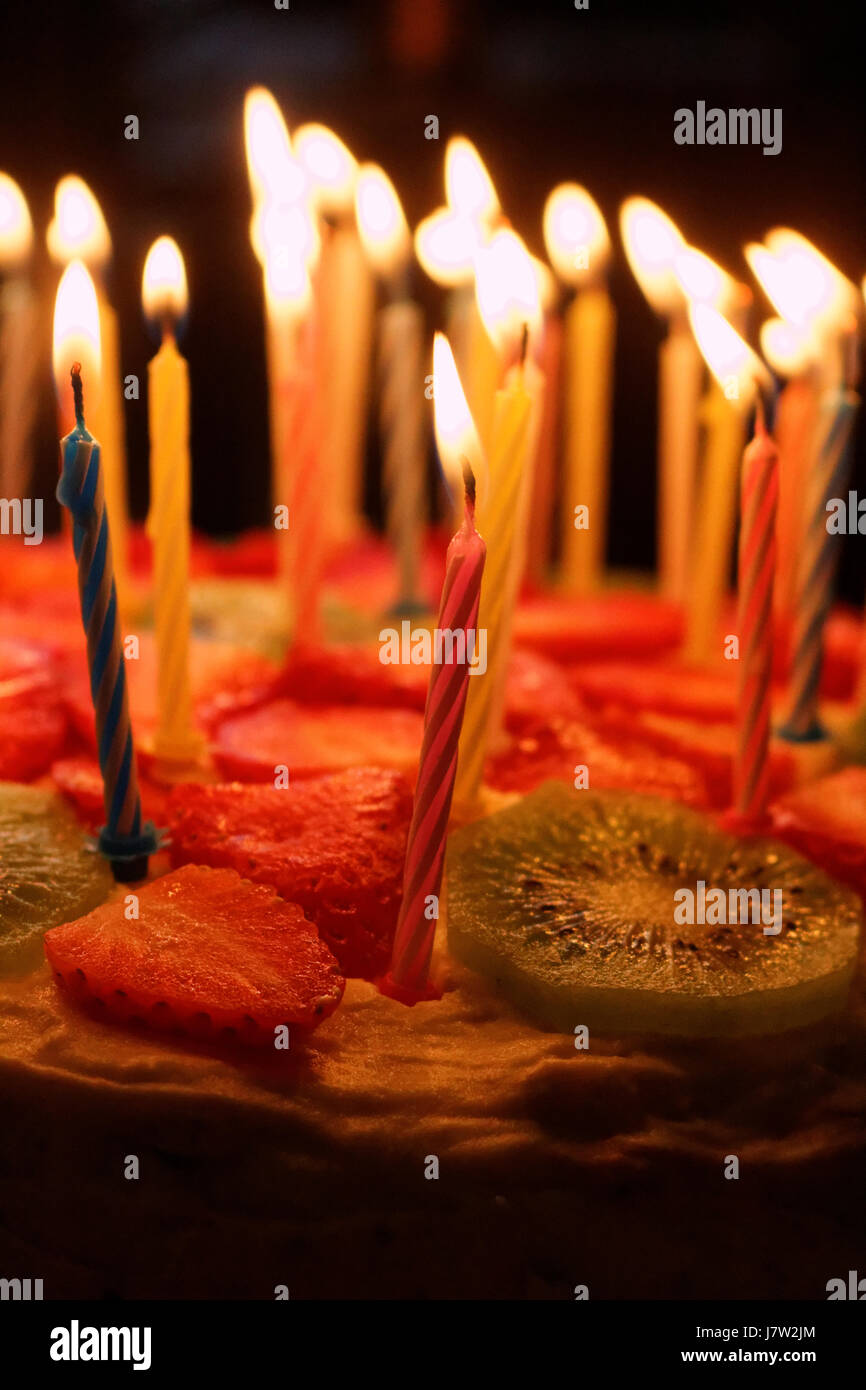Birthday cake with burning candles on a dark background Stock Photo - Alamy