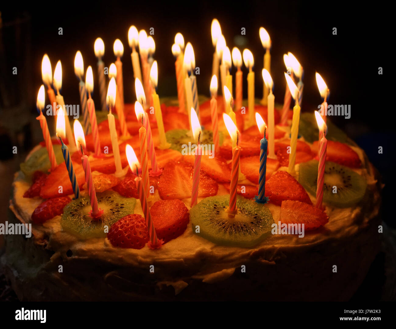 Birthday cake with burning candles on a dark background Stock Photo Alamy