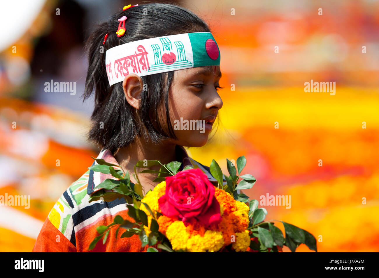 A little girl holds flowers in hand to pay respect to language martyrs at the Central Shaheed Minar. Dhaka, Bangladesh. Stock Photo