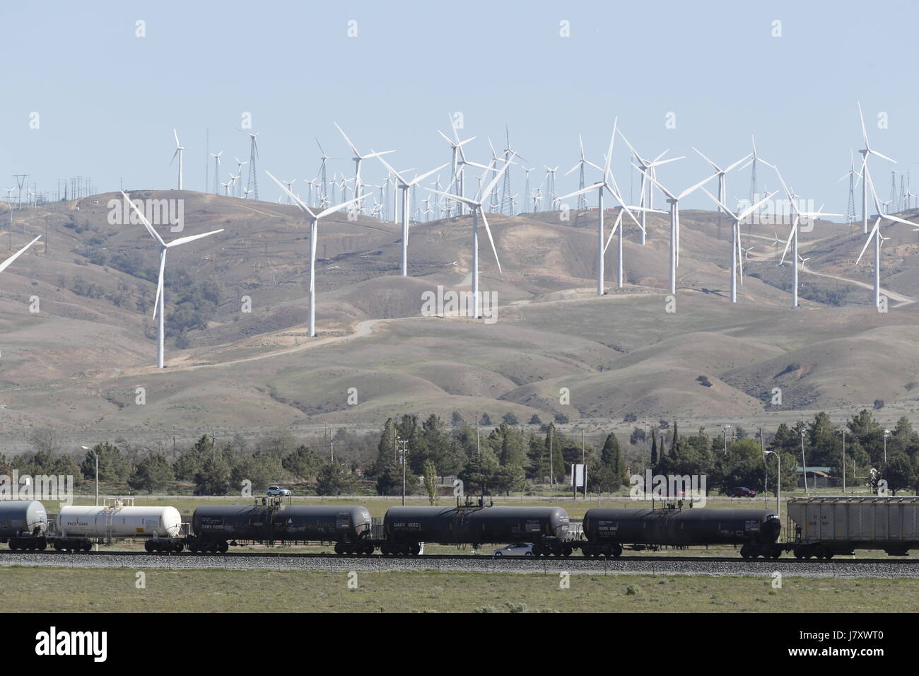 Petroleum cargo train cars pass beneath windmills in the Tehachapi Wind