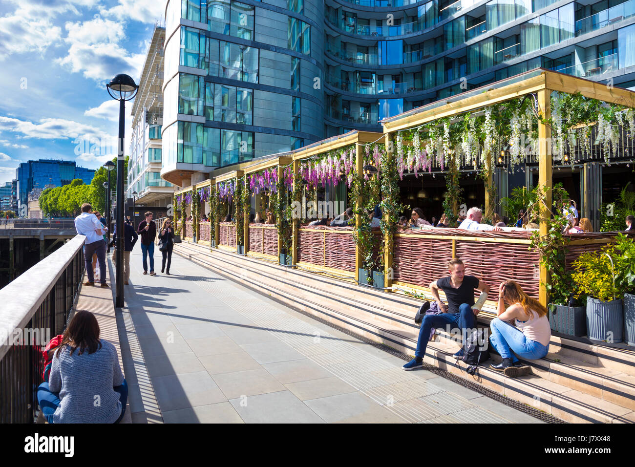 People sitting outside in a bar by the River Thames, Tower Hill, London, UK Stock Photo