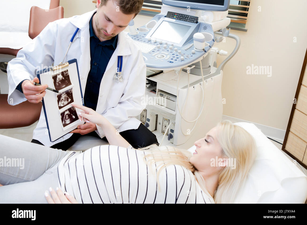 Doctor Showing Baby Ultrasound Image To Pregnant Woman. Showing ...