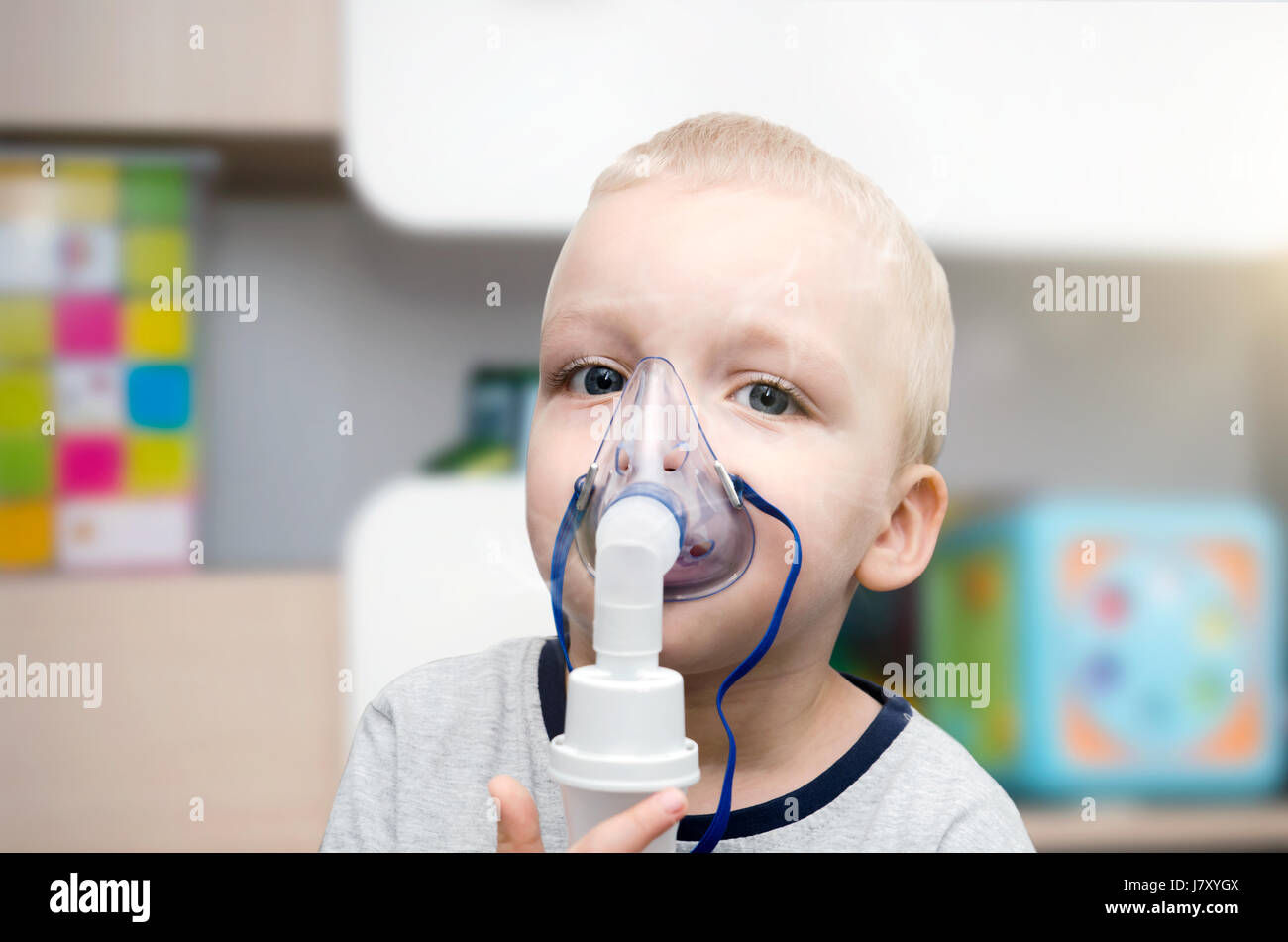 Child making inhalation with mask on his face. Asthma problems concept