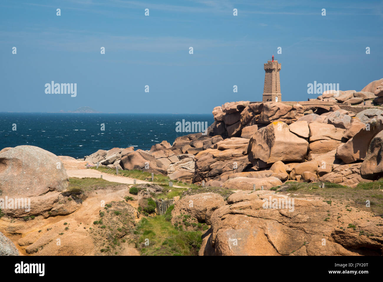 Ploumanach lighthouse, boulders on the Cote de Granit Rose, Pink Granite Coast, Brittany, France, view from Sentier des Douaniers path Stock Photo