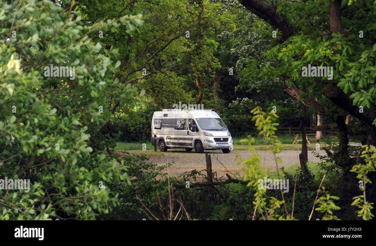 MOTORHOME PARKED IN SECLUDED CAMPING WOODED AREA RE CAMPING CAMPERVAN CAMPER VAN SECLUSION HOLIDAY Stock Photo