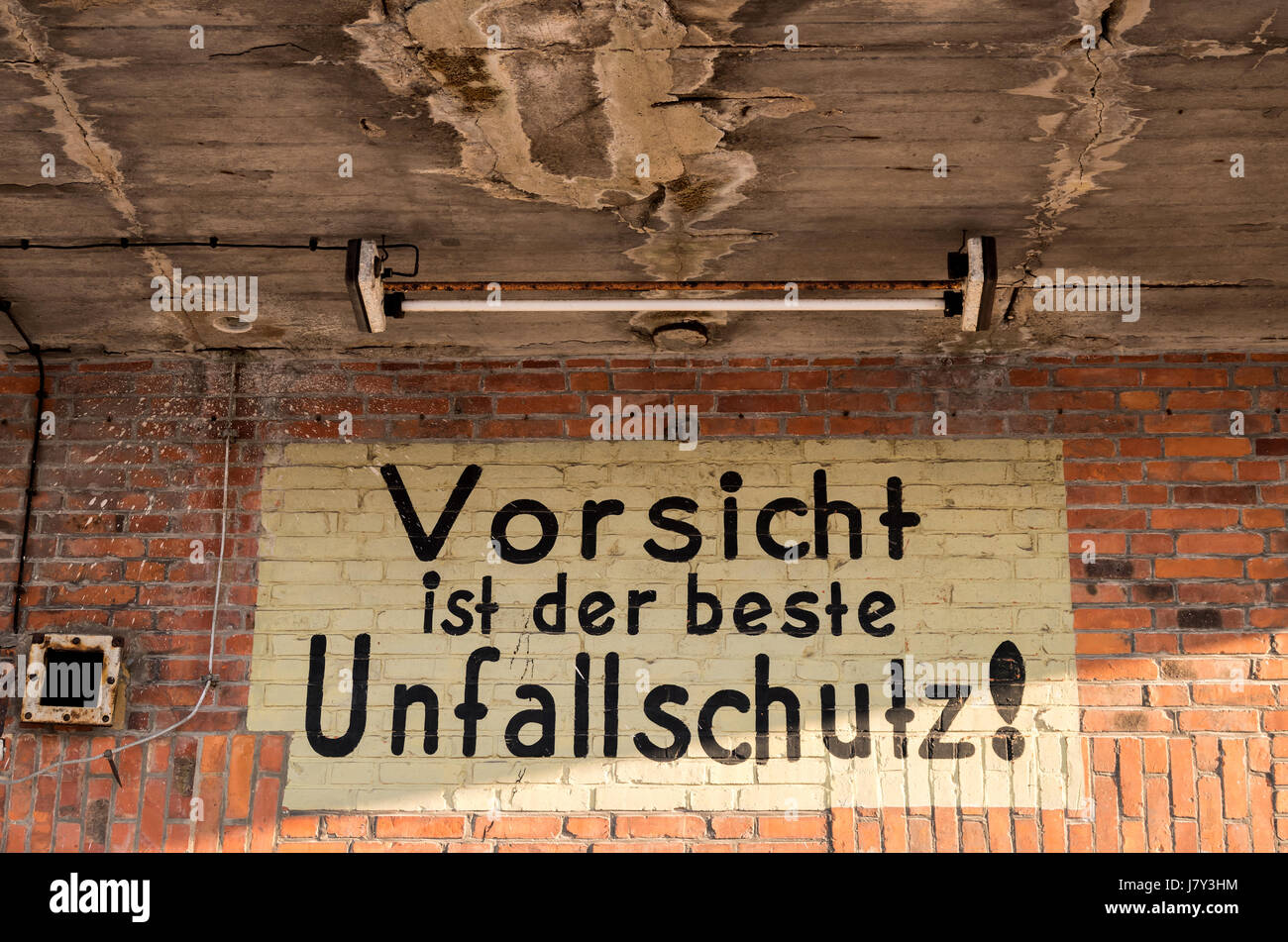 painted warning at old German industrial building (translation caution