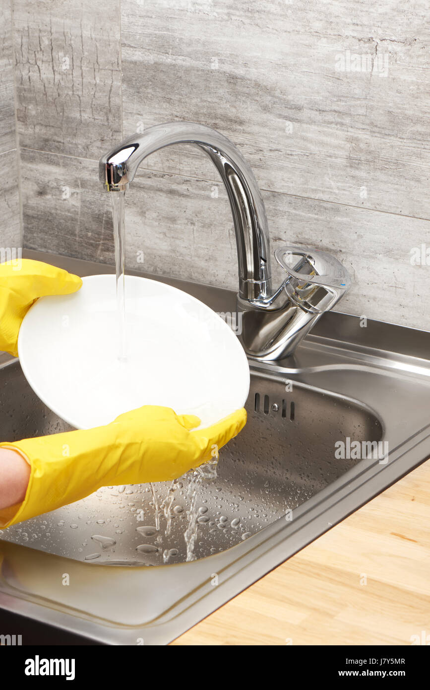 Close up of female hands in yellow protective rubber gloves washing ...