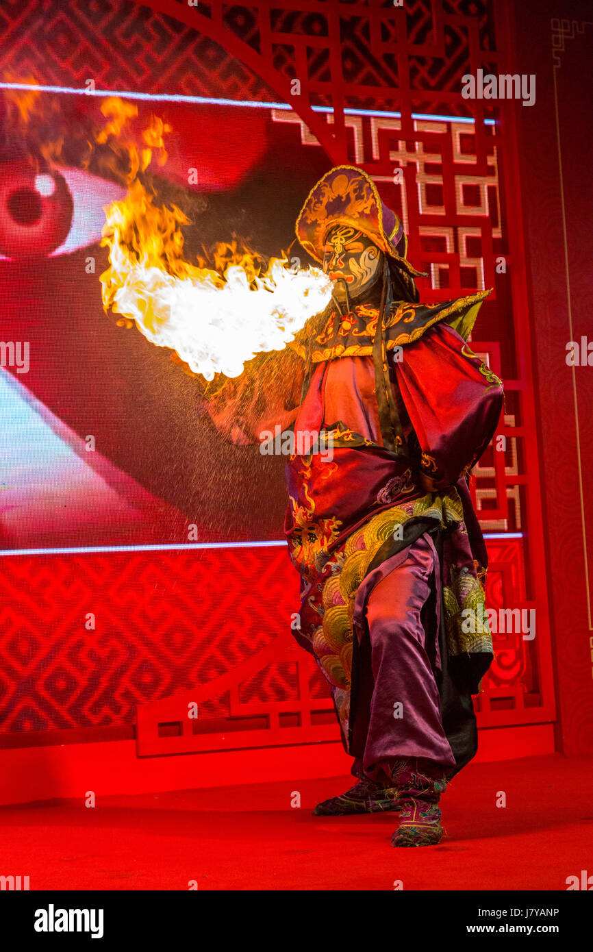 Wenzhou, Zhejiang, China.  Chinese Opera Performer and Face Changing Demonstration.  Fire Emphasizes the Anger of the Character. Stock Photo