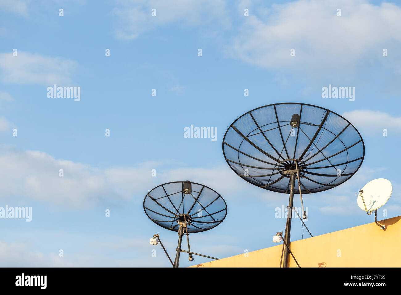 Several satellite dish installed on the house roof with blue sky