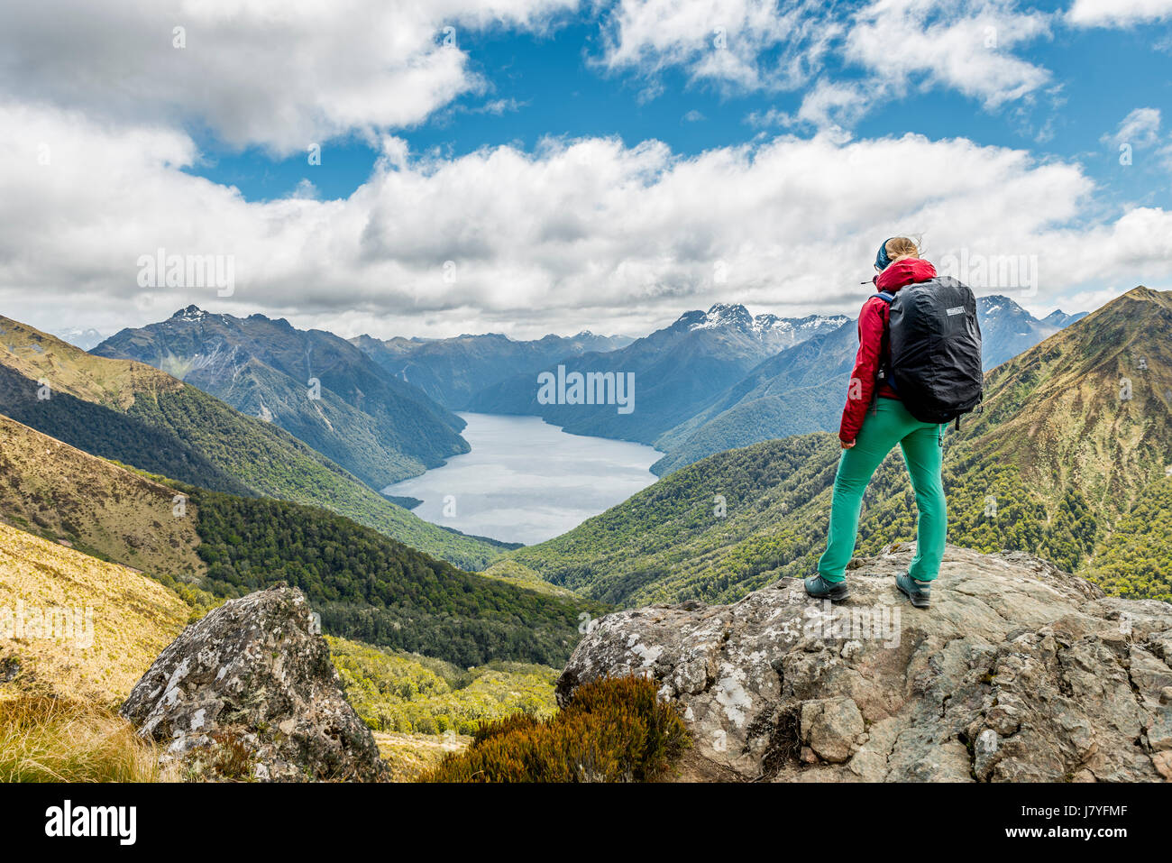 Female hiker looking at the South Fiord of Lake Te Anau, Southern Alps at back, Kepler Tack, Fiordland National Park, Southland Stock Photo