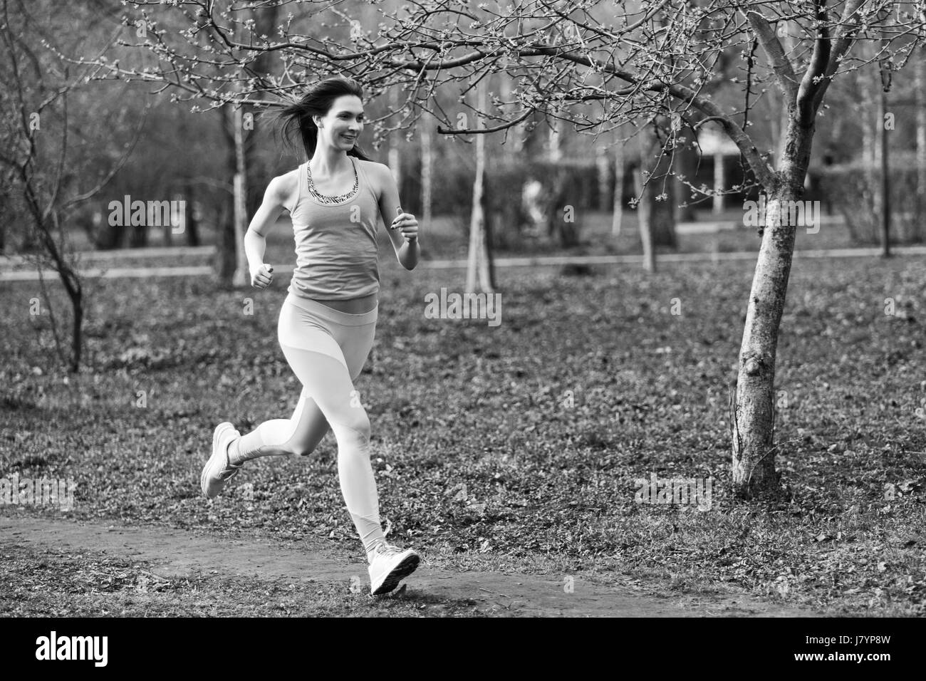 Woman runs through morning park in spring.Black, white photo Stock Photo