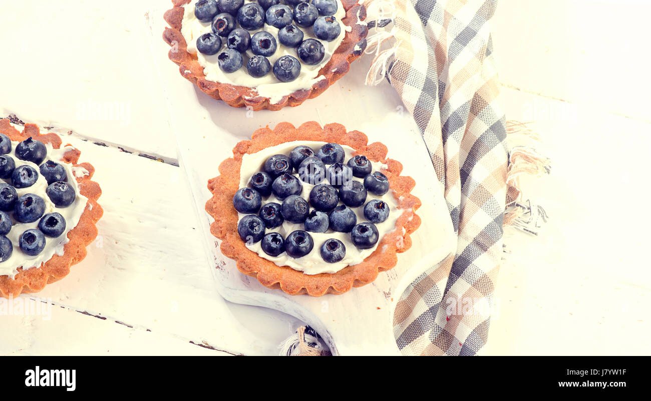 Blueberry tarts on a white wooden board. Stock Photo