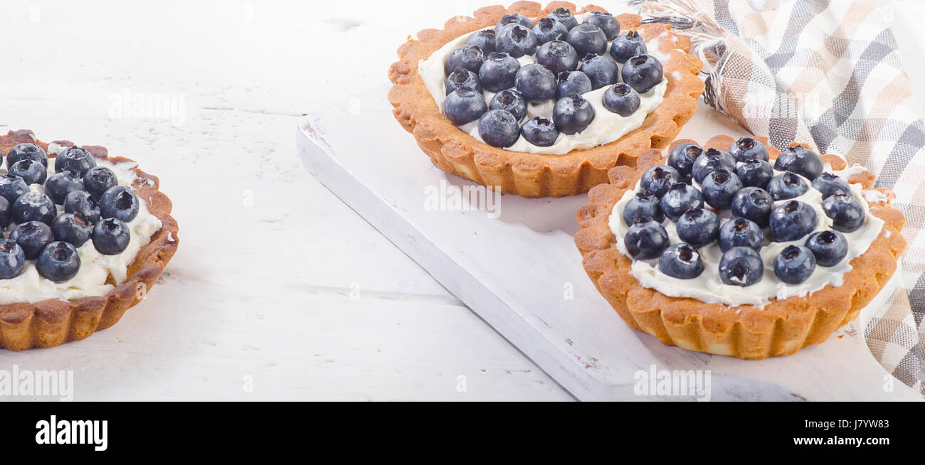 Homemade Blueberry tarts on white wooden board. Panorama Stock Photo