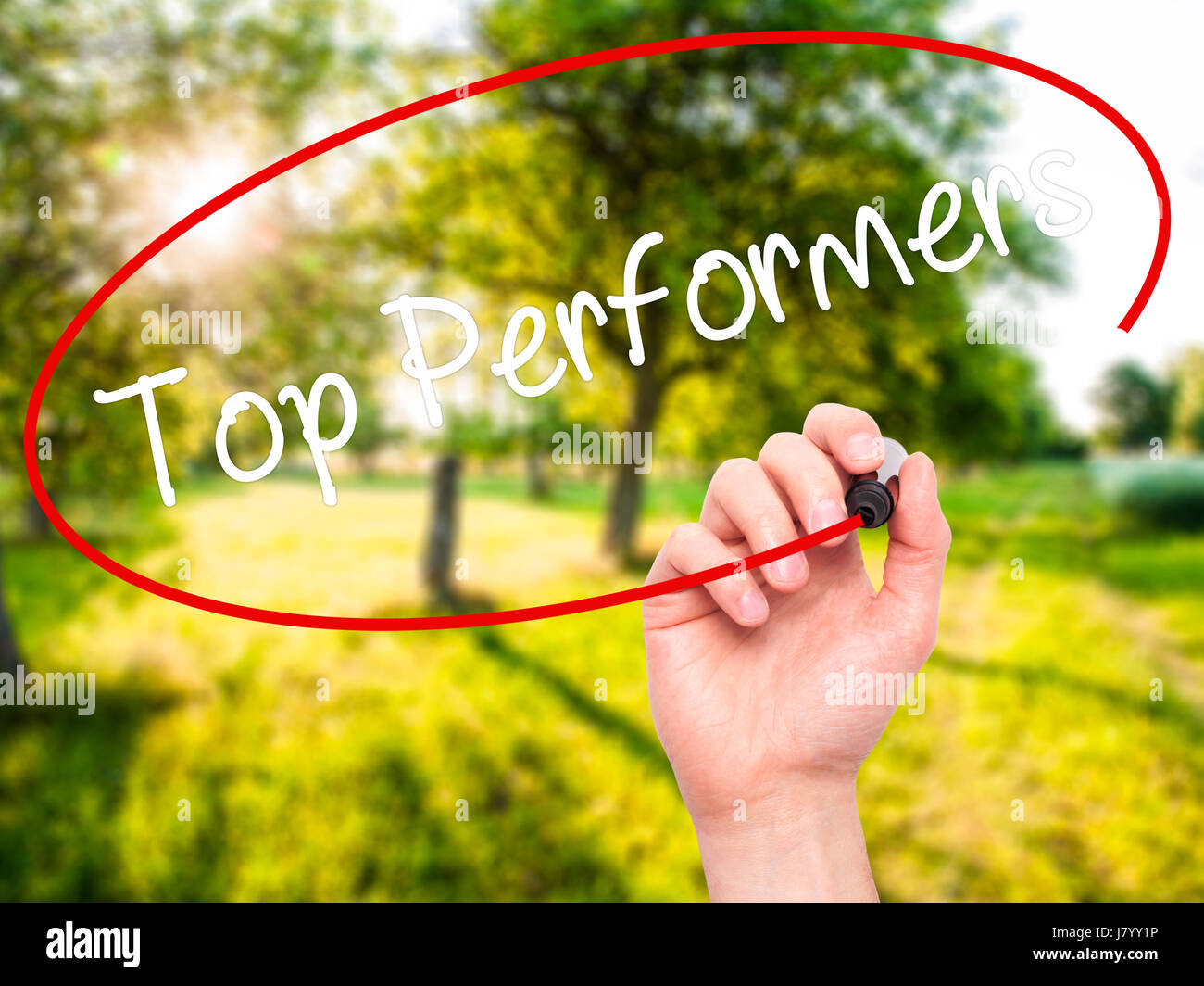 Man Hand writing Top Performers with black marker on visual screen. Isolated on nature. Business, technology, internet concept. Stock Photo Stock Photo