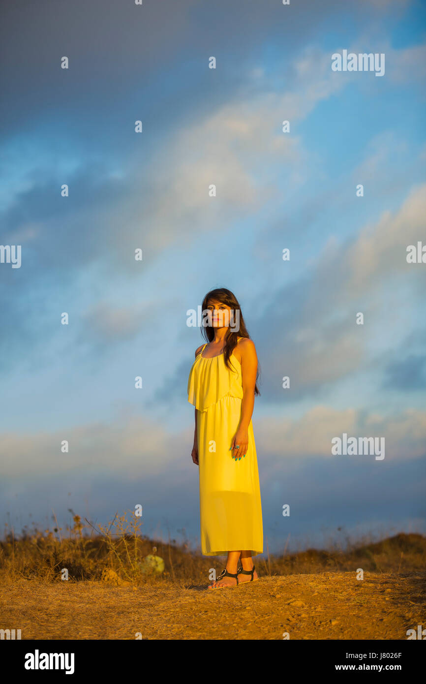 Beautiful woman wearing a yello summer dress standing outdoors Stock ...