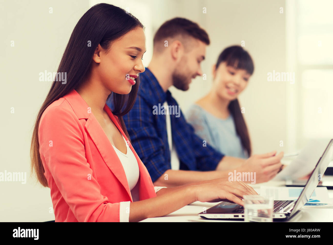 happy african woman over creative team at office Stock Photo - Alamy