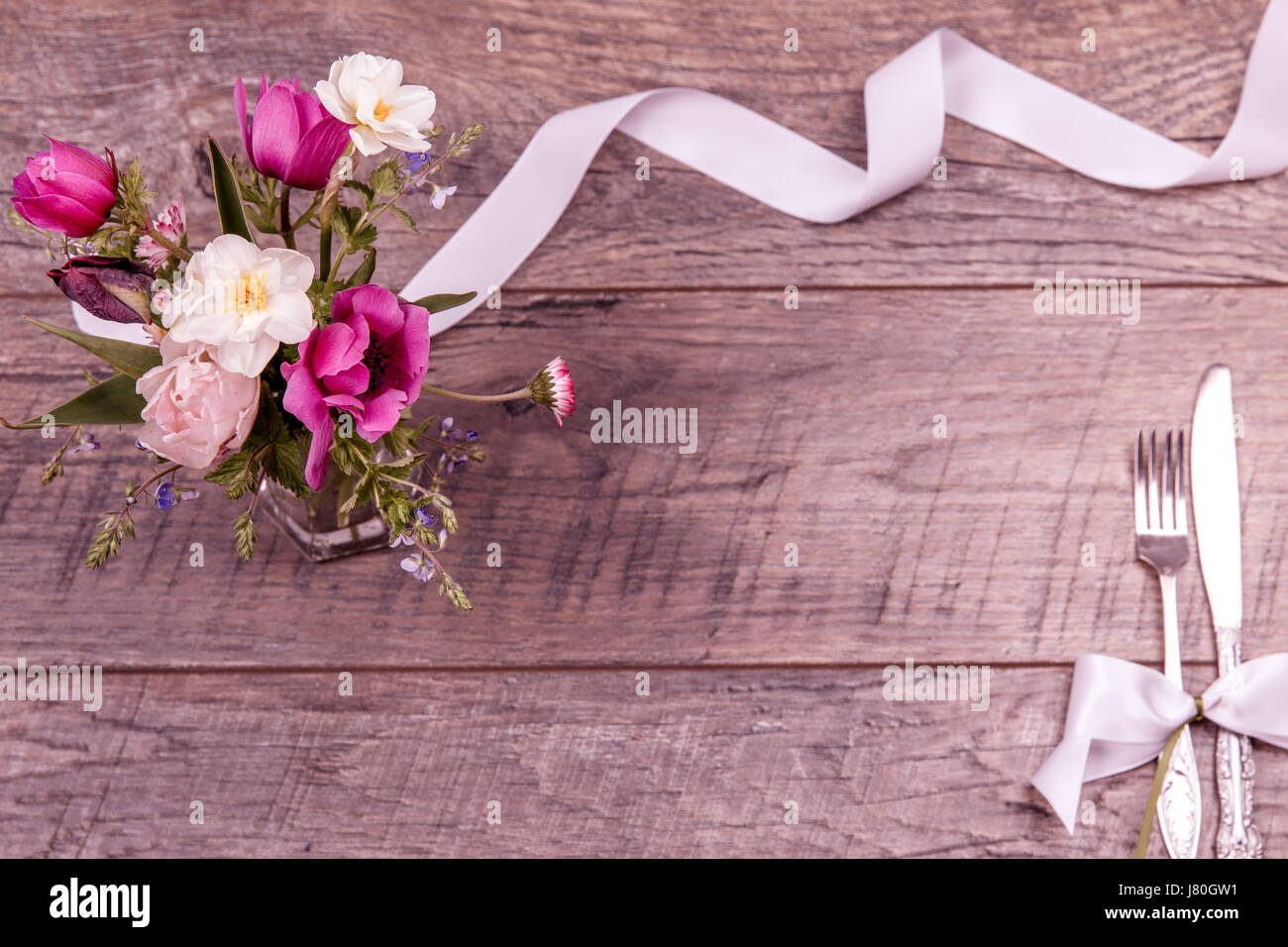 Place table settings with fork and knife, tied with a white satin