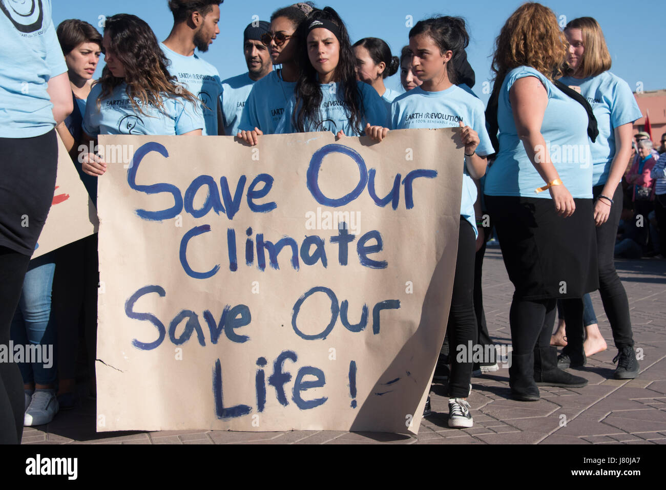 Young activists at the COP22 UN climate conference hold a sign reading 'Save Our Climate, Save Our Life' at a demonstration in Jemaa el-Fnaa, the central market plaza in Marrakech, Morocco, November 10, 2016. Stock Photo