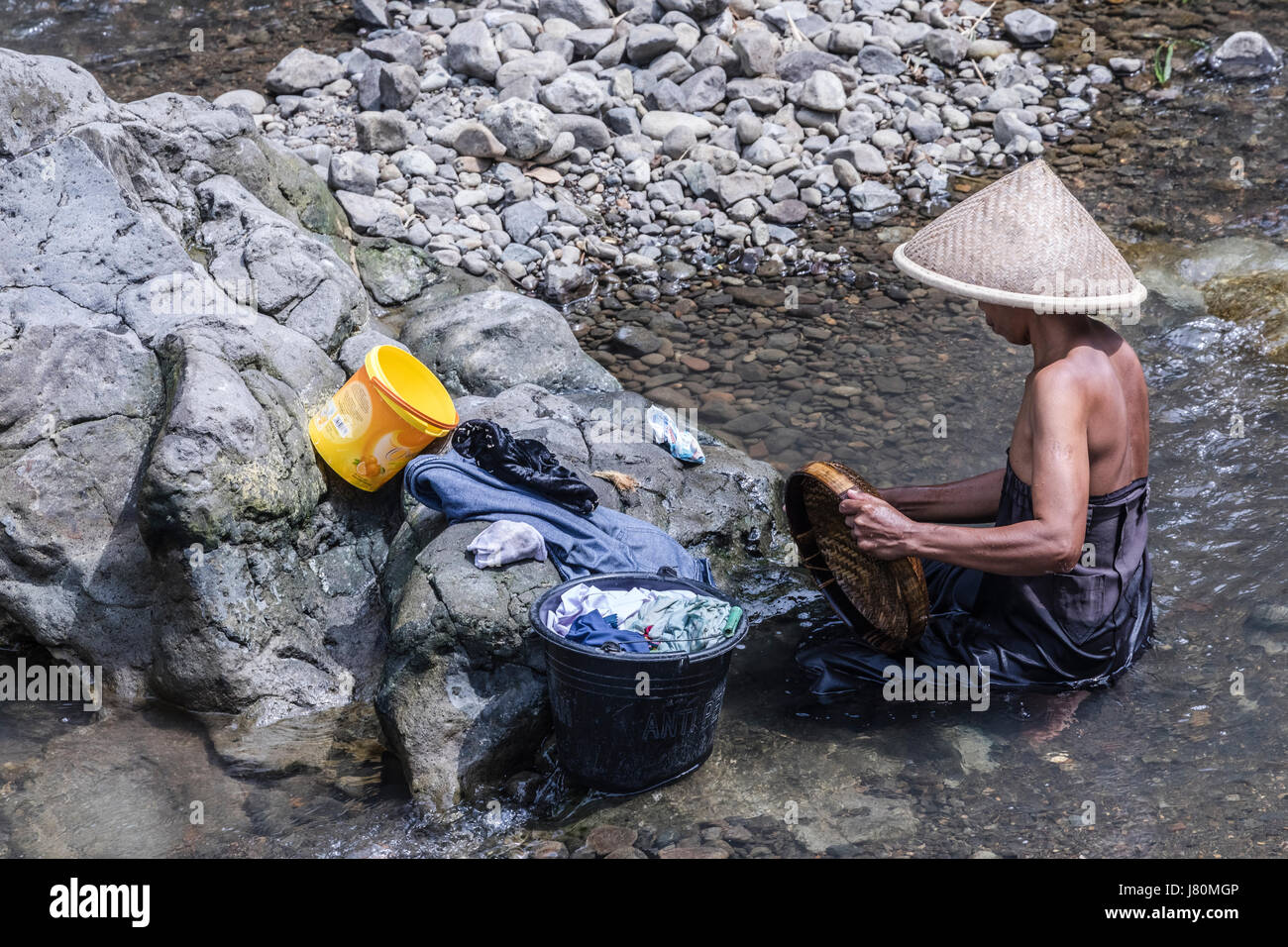 woman doing the laundry in a river in Magelang, Borobudur, Java, Indonesia, Asia Stock Photo