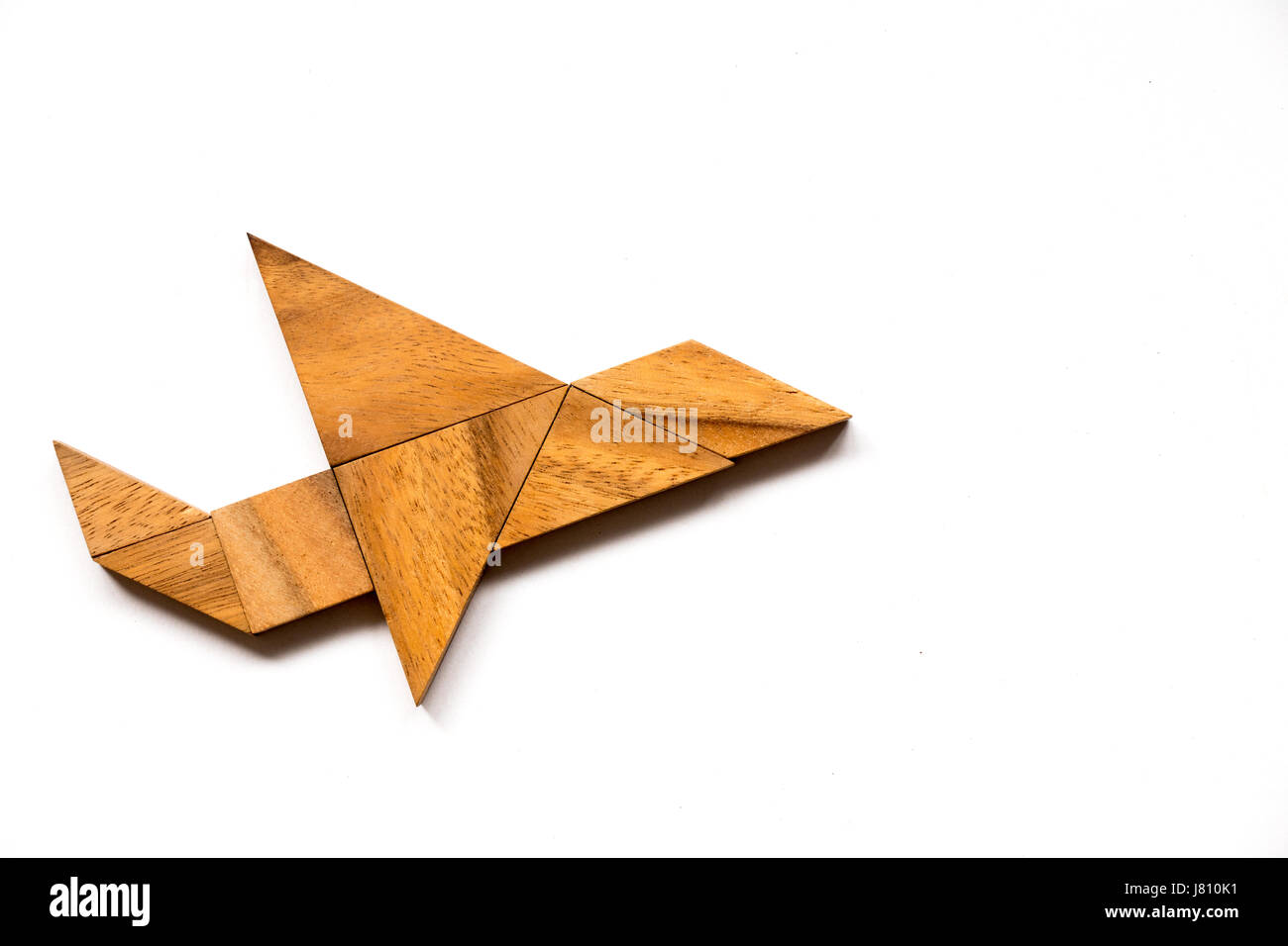 Wooden tangram puzzle in airplane shape on white background (Concept for new experience, start project) Stock Photo