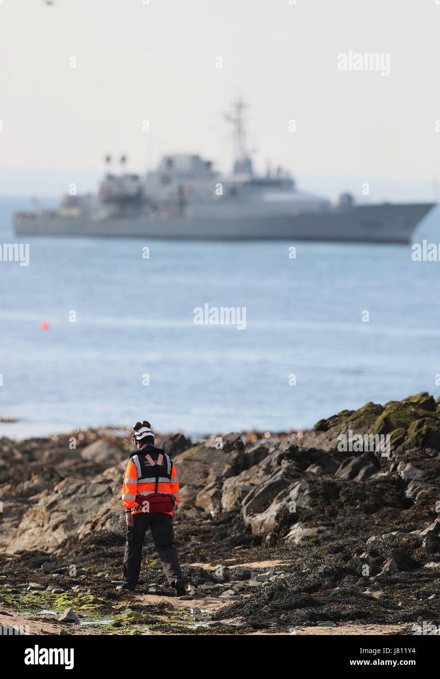 A member of the Irish coast guard searches the coastline in Skerries as a search and rescue operation is under way for a missing fisherman after a boat sank in the Irish Sea. Picture date: Friday May 26, 2017. See PA story SEA Fisherman Ireland. Photo credit should read: Brian Lawless/PA Wire Stock Photo
