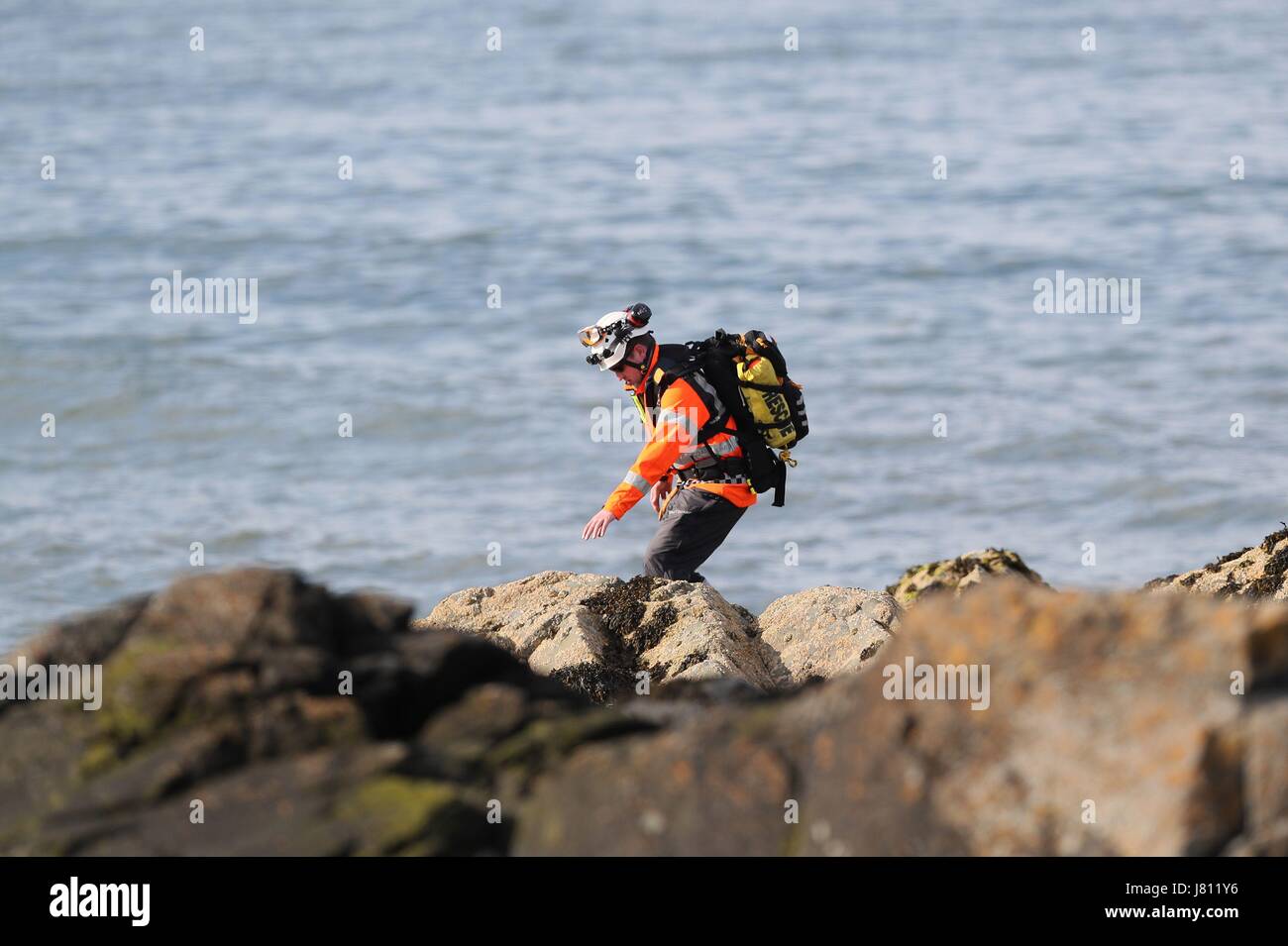 A member of the Irish coast guard searches the coastline in Skerries as a search and rescue operation is under way for a missing fisherman after a boat sank in the Irish Sea. Picture date: Friday May 26, 2017. See PA story SEA Fisherman Ireland. Photo credit should read: Brian Lawless/PA Wire Stock Photo