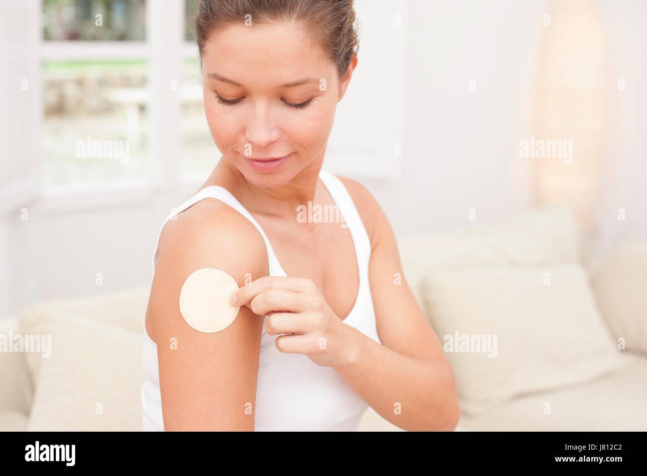 Woman applying nicotine path to arm. Stock Photo