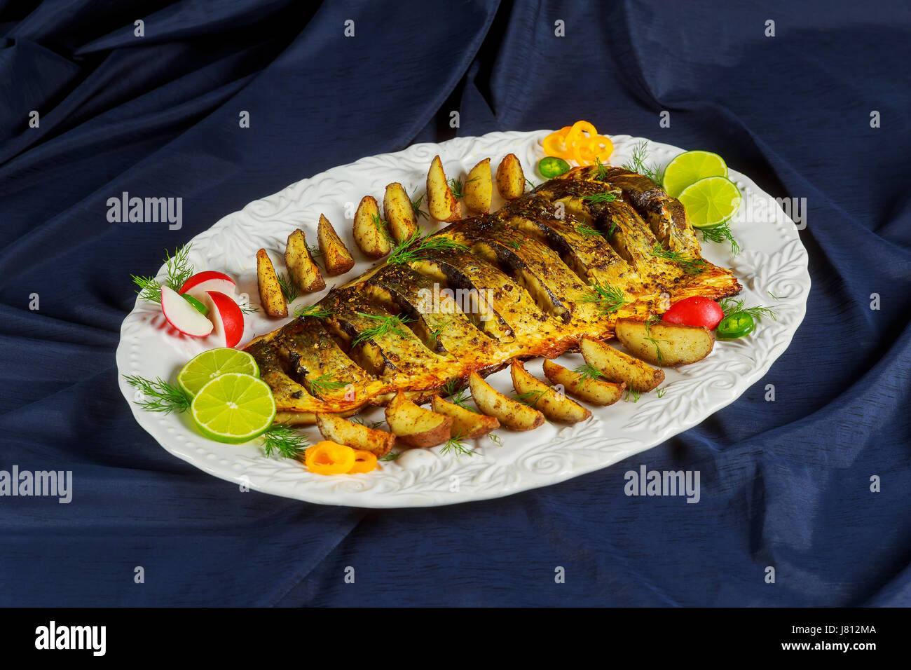 Oven baked Grilled fish with roasted potatoes and vegetables on the
