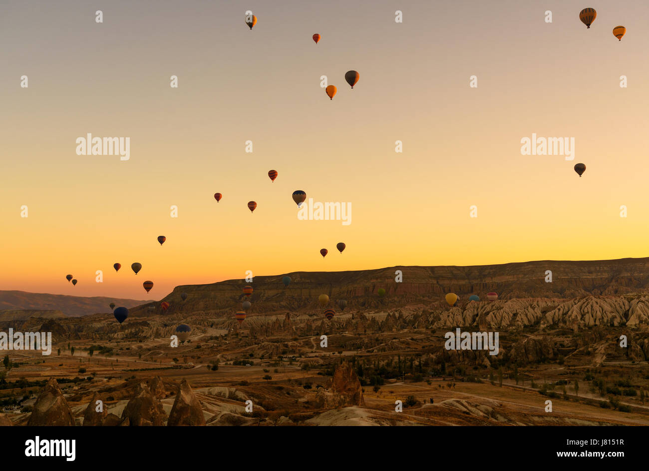 Hot air balloons flying over valley of Cappadocia at sunrise. Nevsehir ...