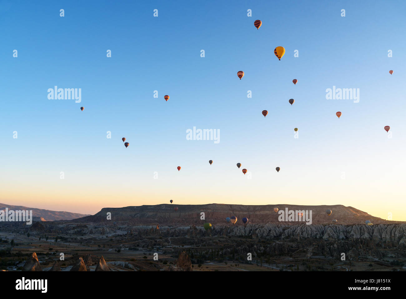 Hot air balloons flying over valley of Cappadocia at sunrise. Nevsehir ...