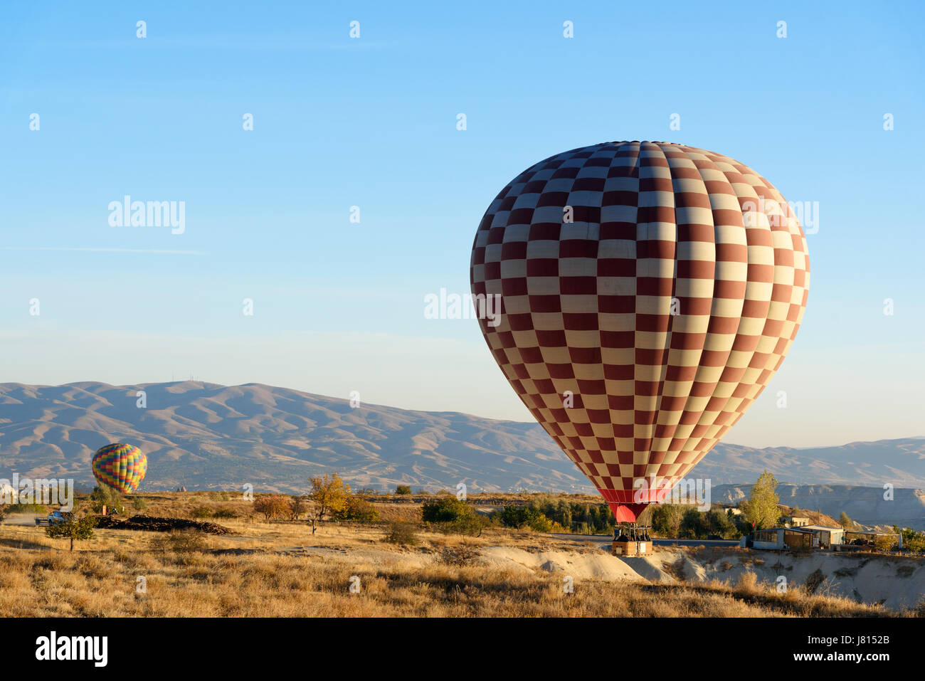 Hot air balloons landing after flight over valley of Cappadocia in the morning. Nevsehir Province. Turkey. Stock Photo