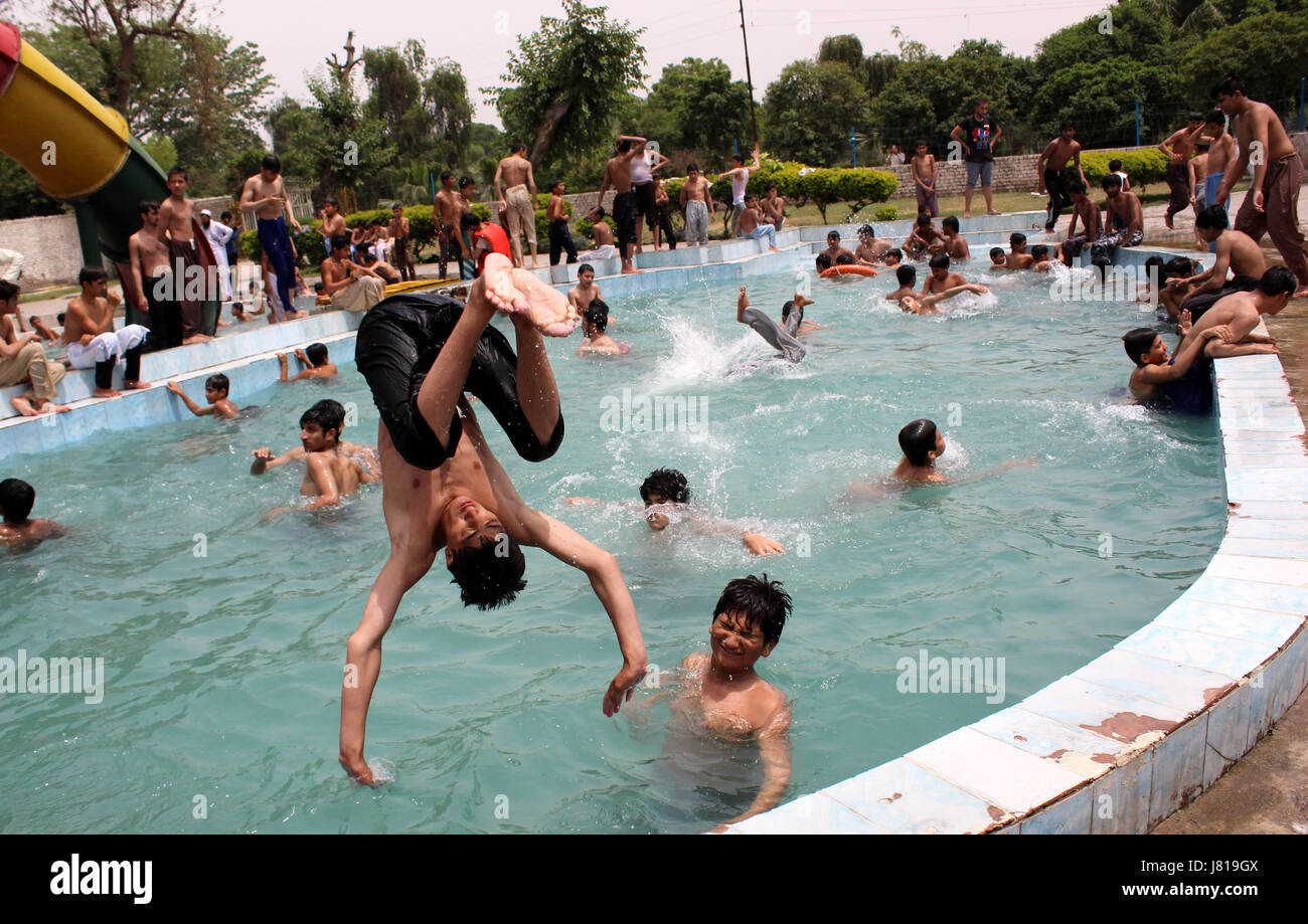 Peshawar. 26th May, 2017. A Pakistani boy jumps into a swimming pool to